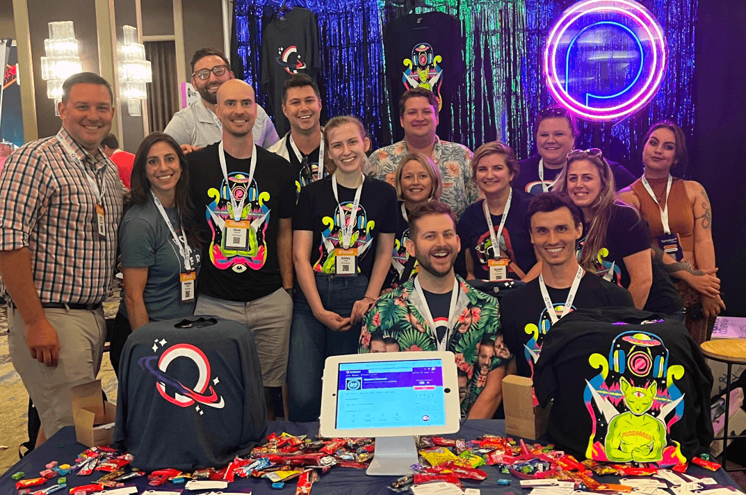 Podchaser team smiling at event booth